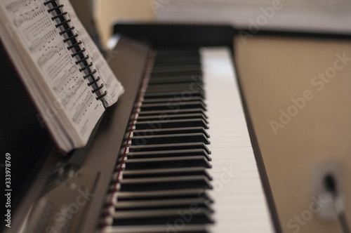 Shallow focus shot of a piano with a songbook photo