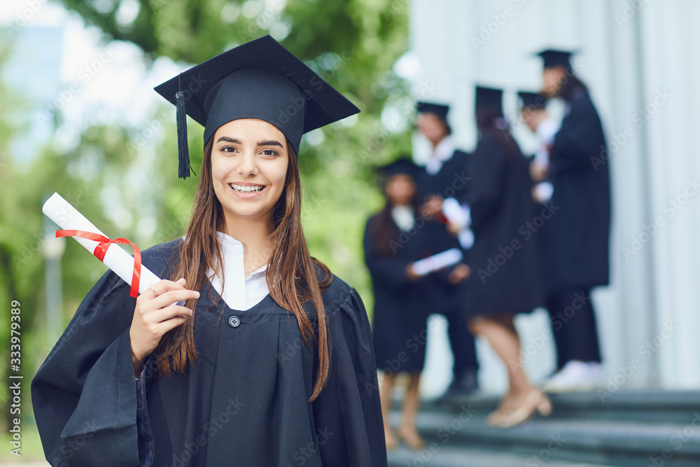 A young female graduate against the background of university graduates.  Stock Photo