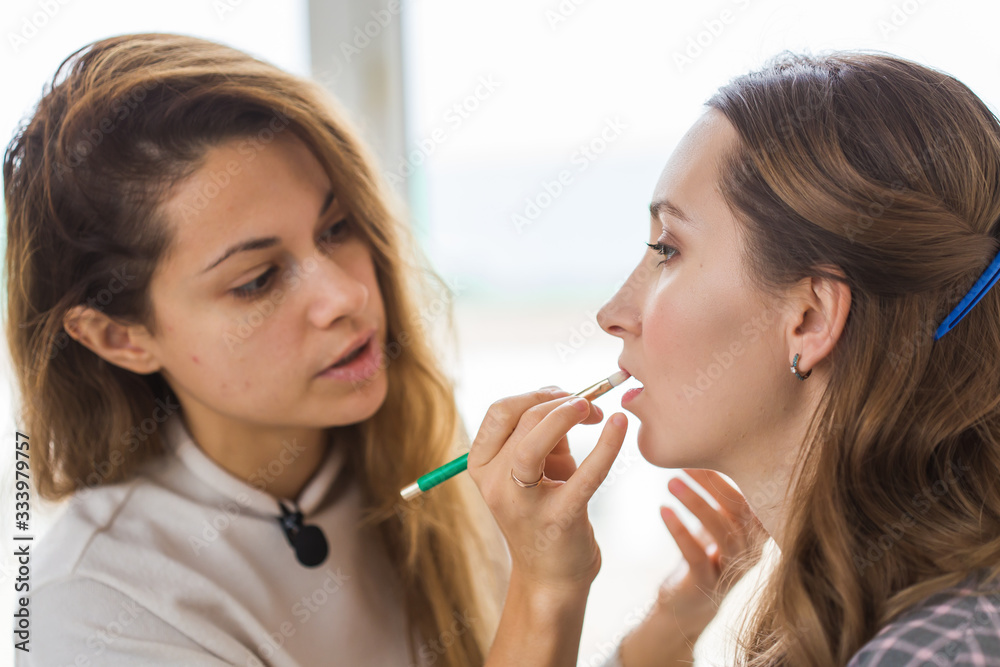 Beauty and cosmetics concept - Makeup artist doing professional make up of young woman Beauty and cosmetics concept - Makeup artist doing professional make up of young woman