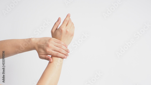 Foto Male model is rub wrist to mid-upper arm in a rotating manner on white background