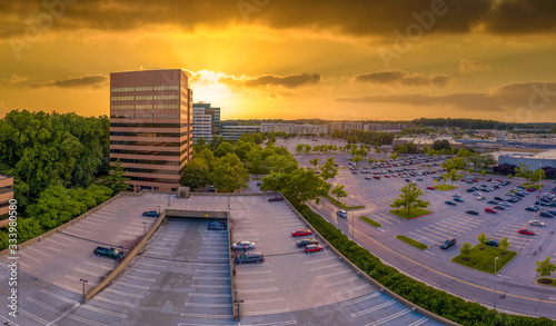 Yellow, orange sunset sky behind the commercial office buildings at Columbia Town Center Howard County Maryland United States photo