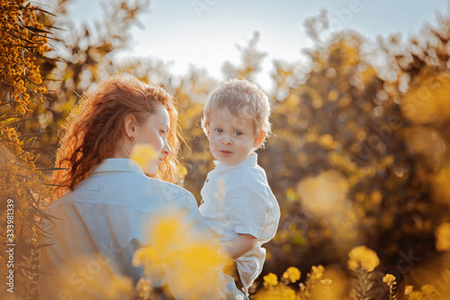 Mother and child enjoy early spring in blooming yellow flowers field or garden eco friendly in harmony with nature. Happy Mothers day holiday concept. Earth day family celebration seasonal greeting