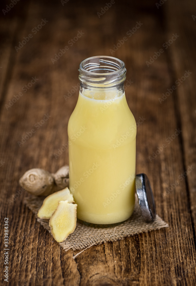 Old wooden table with fresh Ginger Juice (close-up shot; selective focus) Old wooden table with fresh Ginger Juice (close-up shot; selective focus)