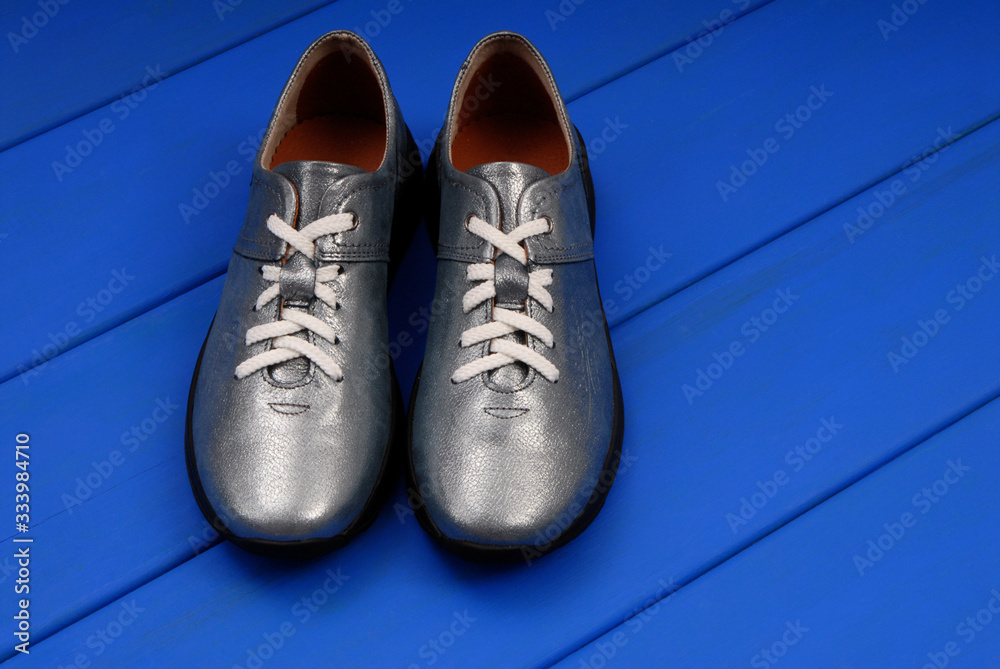 leather sneakers, light blue footwear on blue floor, leather sneakers, light blue footwear on blue floor,