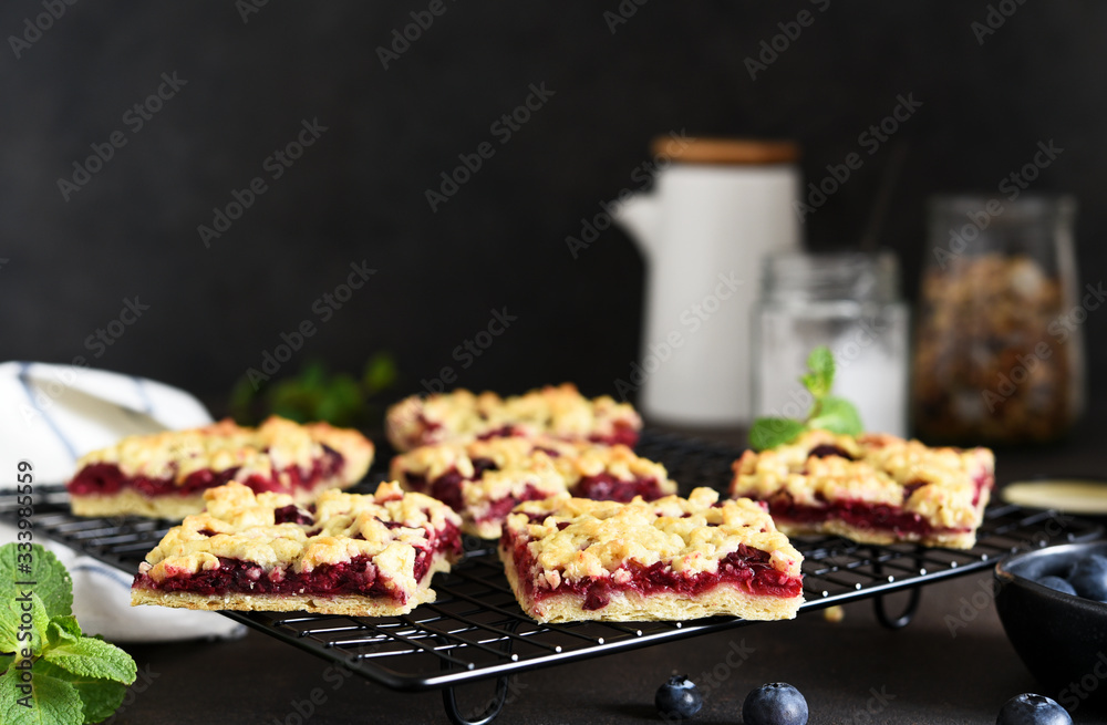 Tasty grated pie with cherries and blueberries on a dark background. Horizontal focus. Tasty grated pie with cherries and blueberries on a dark background. Horizontal focus.