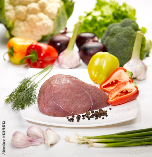 raw meat and vegetables on the kitchen table