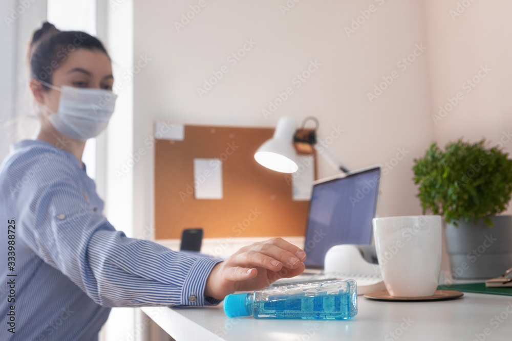 Coronavirus. Woman working from home wearing protective mask in quarantine. Home office concept during COVID-19