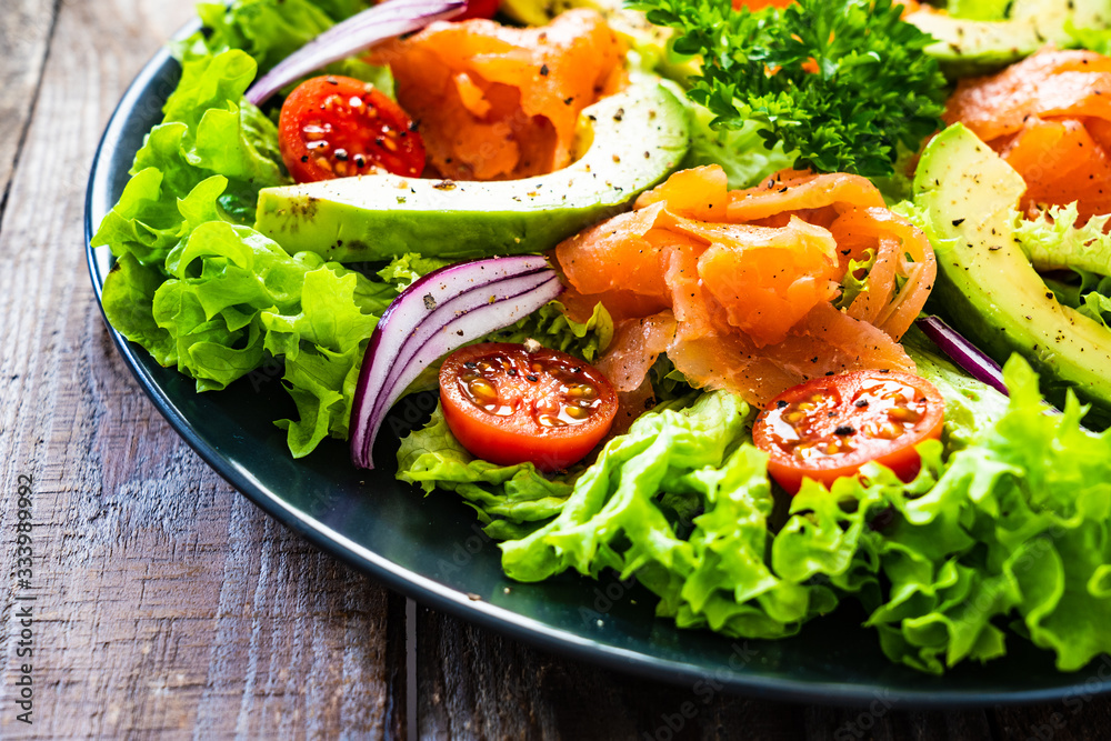 Salmon salad - smoked salmon and vegetables on wooden background Salmon salad - smoked salmon and vegetables on wooden background