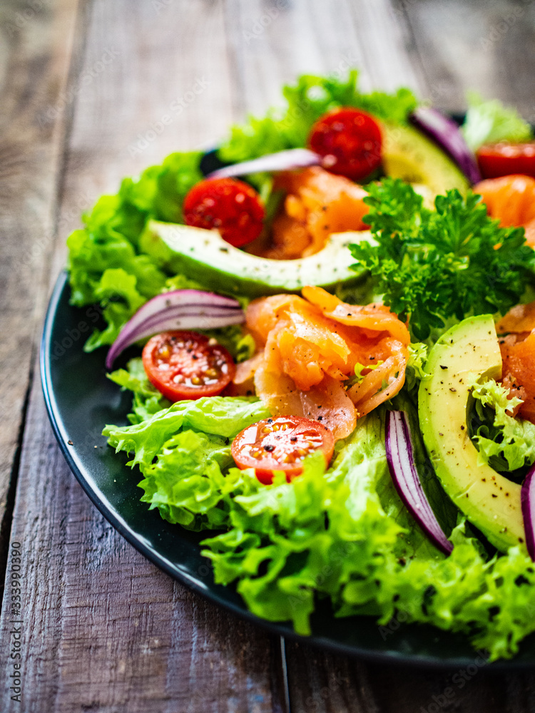Salmon salad - smoked salmon and vegetables on wooden background Salmon salad - smoked salmon and vegetables on wooden background