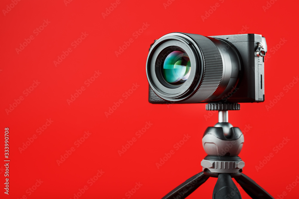 Professional camera on a tripod, on a red background. Record videos and  photos for your blog, reportage Stock-Foto | Adobe Stock