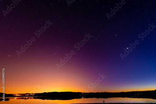 Late sunset on the lake. Beautiful night starry sky.