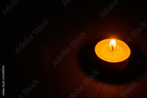 One burning circle candle on dark background