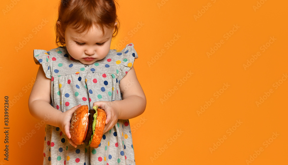 Little girl with hamburger in her hands. Little girl with hamburger in her hands.