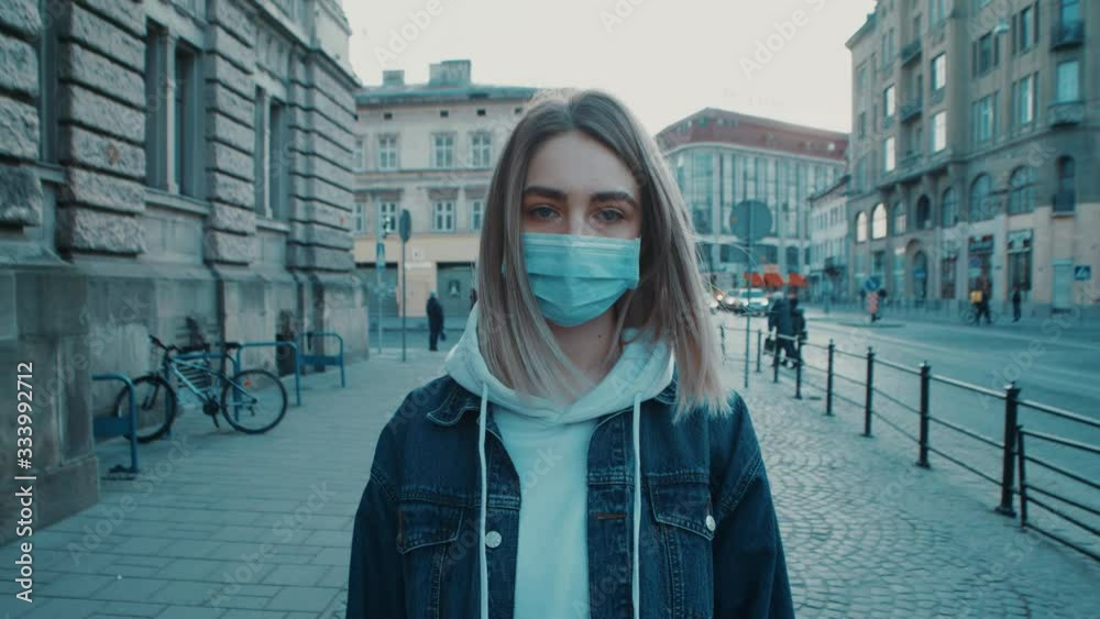 Young caucasian woman standing on the sreet and wearing protective mask virus covid19 coronavirus pandemic city pretty women focused on camera close up