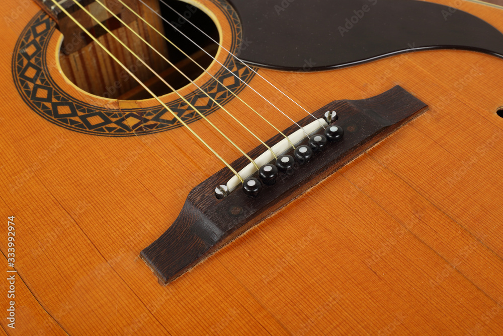 Fototapeta premium Musical instrument - Top view pickguard, bridge, pins and strings retro acoustic guitar