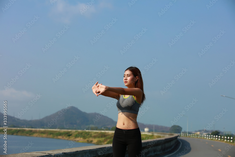 Healthy young woman warming up outdoors. Healthy woman is stretching her arms and hand before do outdoor exercise Healthy young woman warming up outdoors. Healthy woman is stretching her arms and hand before do outdoor exercise