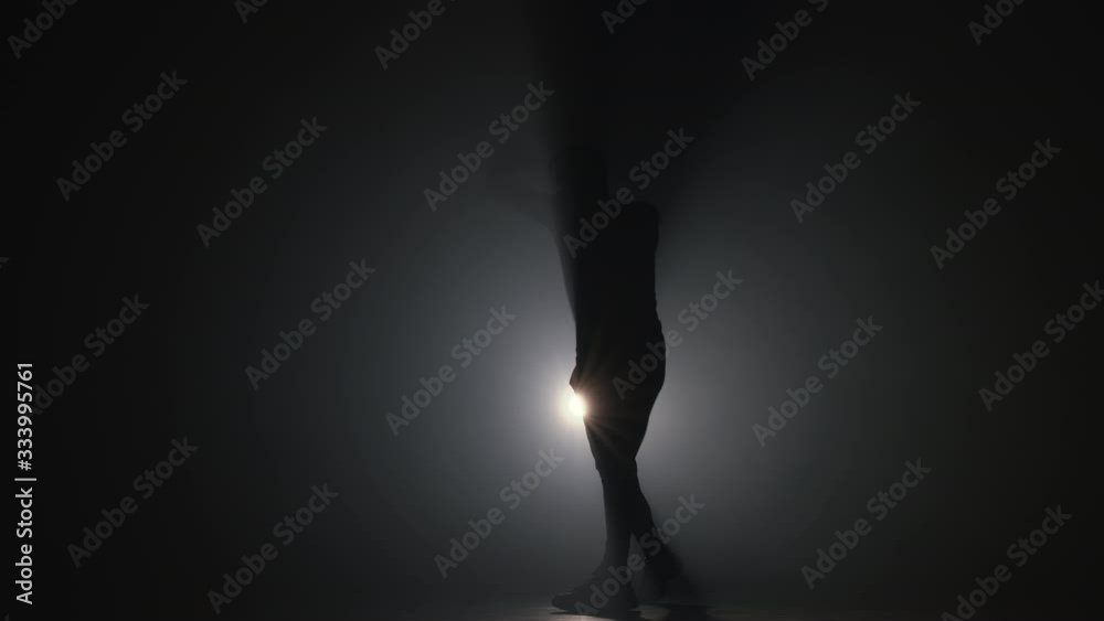 Silhouette of young man boxer practicing boxing punches, training in dark smoky studio. Workout in gym, strength exercise, 4k slow motion Silhouette of young man boxer practicing boxing punches, training in dark smoky studio. Workout in gym, strength exercise, 4k slow motion