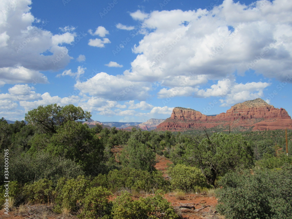 View of red rock mountains near Sedona, Arizona with clouds and blue sky in the background 