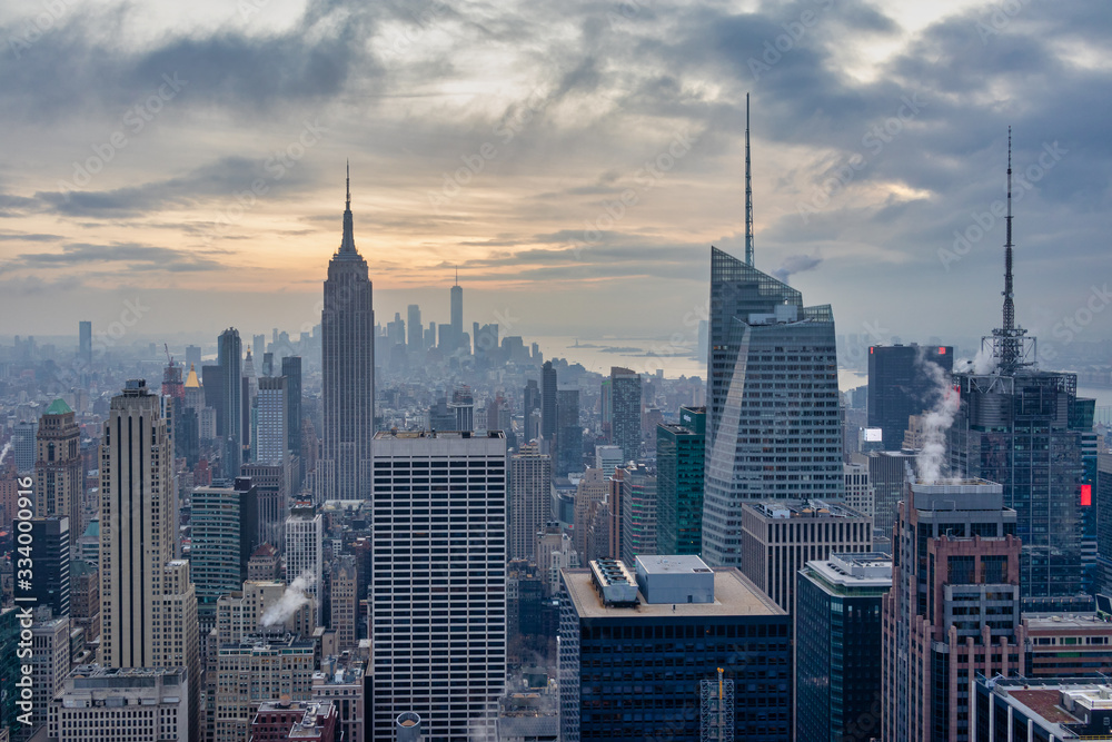 Fototapeta premium New York skyline from the top of Top of the Rock (Rockefeller Center)sunset view in Winter with clouds in the sky