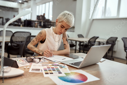 Creating something new. Young and beautiful creative female designer making a sketch while sitting at her workplace in the office