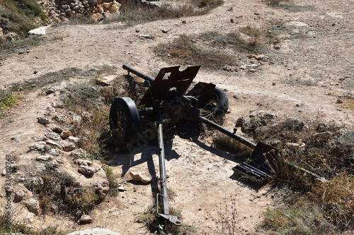 Photography An old cannon, the armament of soldiers, as a monument to the edification of posterity, stands in a trench, on the site of fierce battles in the Great Patriotic War