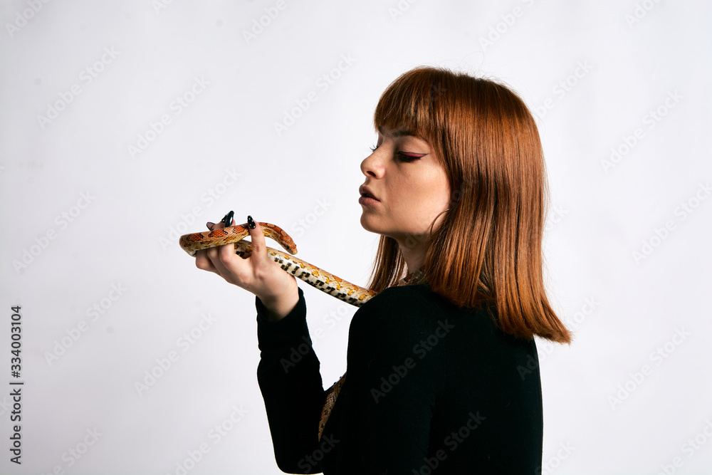 Beautiful woman in black bodywear and snake. Ginger model girl with fashion perfect make up. Beautiful woman in black bodywear and snake. Ginger model girl with fashion perfect make up.