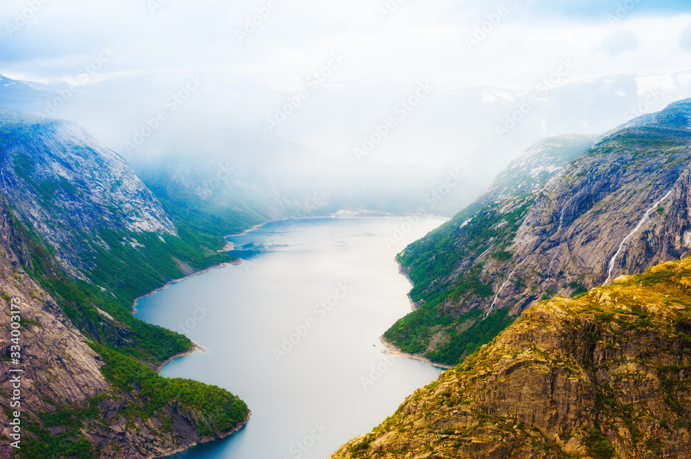 Lake in the mountains in foggy morning, Norway. Ringedalsvatnet lake on the hiking trek to Trolltunga. Summer landscape