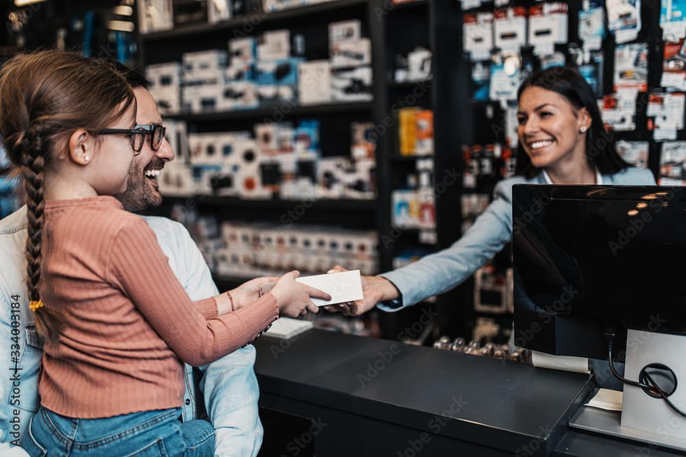 Father and daughter buying in tech store. Father and daughter buying in tech store.