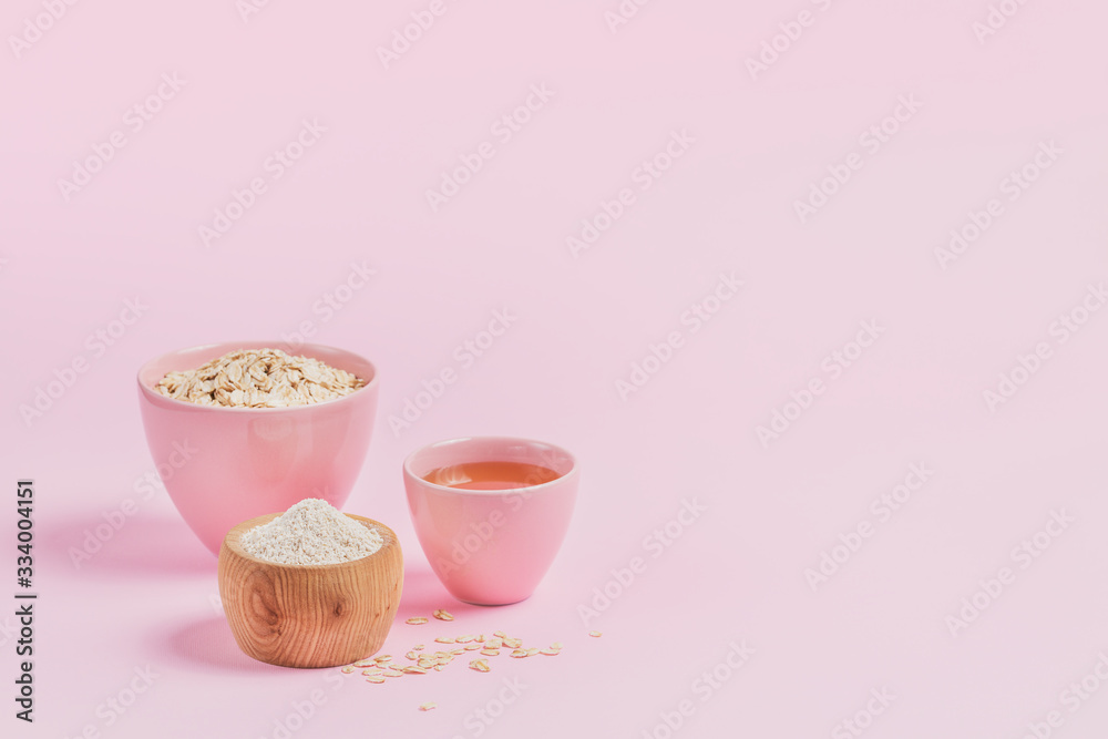 Bowl of dry oat flakes with honey and oatmeal on light background. Healthy skin, facial and body care.