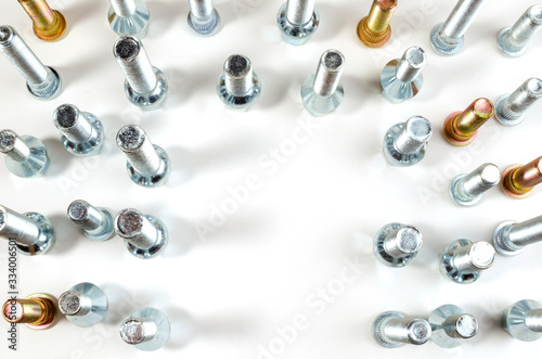 on a white background close-up new shiny nuts and bolts of a car top view