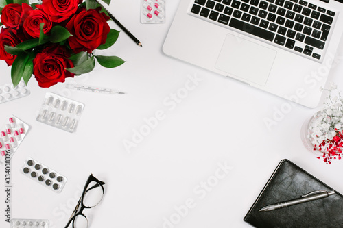 Work at home when sick. Remote work, epidemic and isolation concept with copyspace, roses bouquet, laptop and notebook © moshbidon