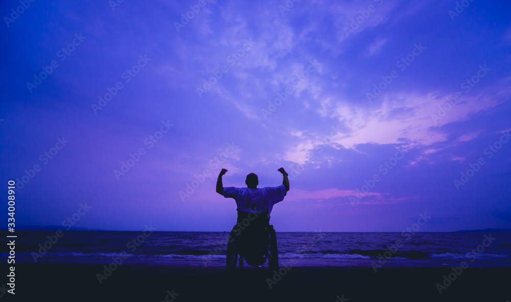Disabled man in a wheelchair on the beach. - obrazy, fototapety, plakaty 