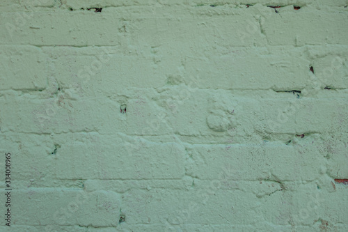 abstract background of an old brick wall painted light green close up