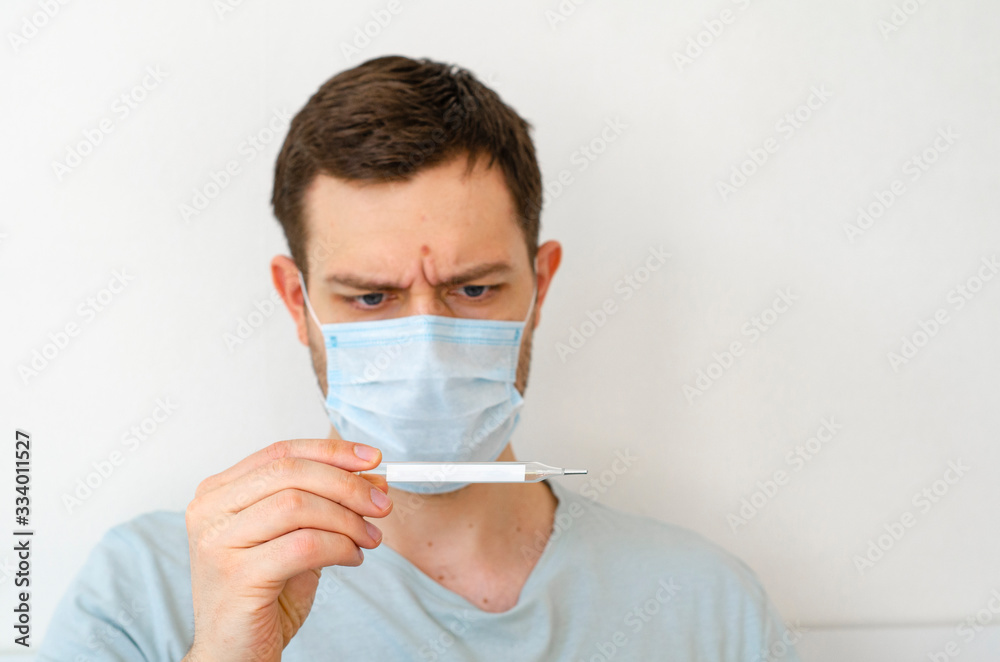 Coronavirus. Quarantine. A man measures the temperature. Heat. In the mask.