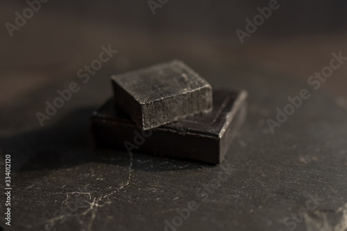 Fototapeta Naklejka Na Ścianę i Meble -  Black carbon charcoal soap on a black granit background 
