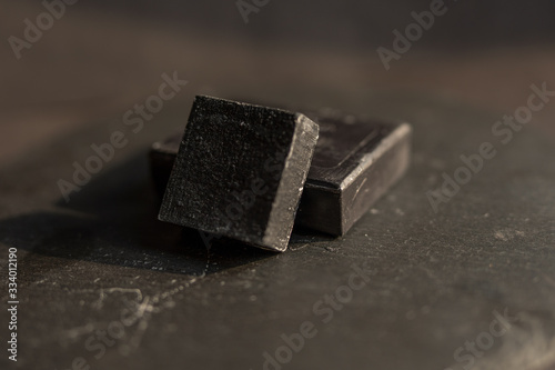 Black carbon charcoal soap on a black granit background 