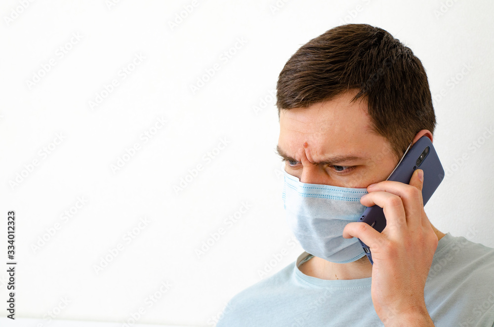 Coronavirus. Quarantine. A man solves work issues remotely. In the mask. Coronavirus. Quarantine. A man solves work issues remotely. In the mask.