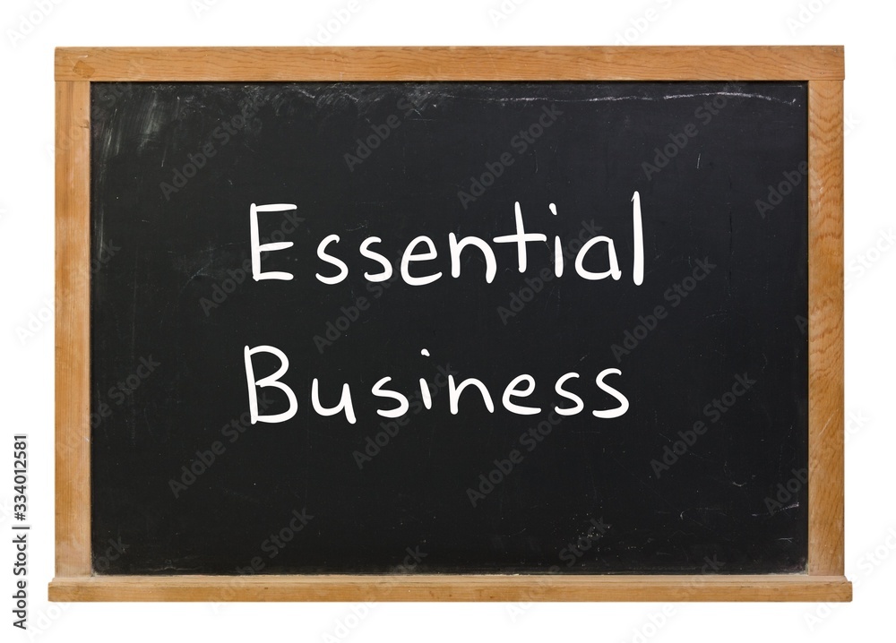 Essential Business written in white chalk on a black chalkboard isolated on white Essential Business written in white chalk on a black chalkboard isolated on white