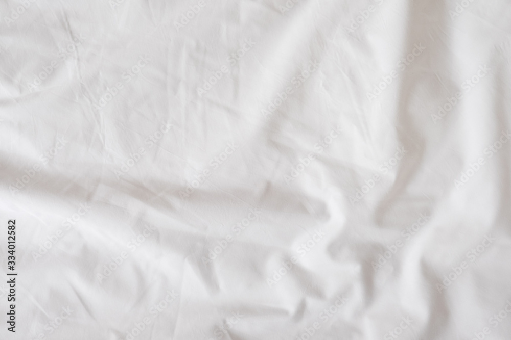 Background of white rumpled sheets. Bed linen with wrinkles in day light. Horizontal. Copy spase. Concept of rest, awakening, sleep, stay at home. For social media, blog