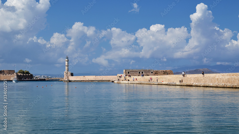 View of the port of Chania and the lighthouse surrounded by clear water, second largest city of Crete island, Greece.