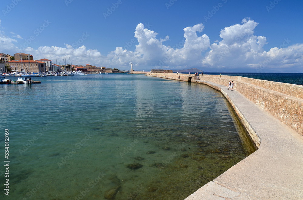 View of the port of Chania and the lighthouse surrounded by clear water, second largest city of Crete island, Greece.