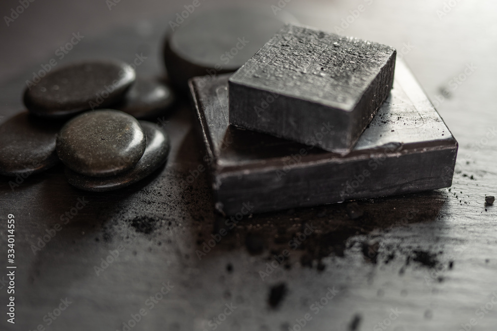 Black carbon charcoal soap on a black granit background 