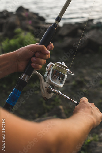fisherman holds in his hands and spins spinning coil