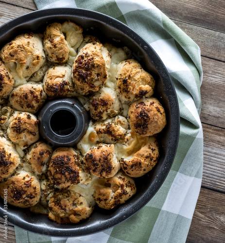 A close up top down view of a bundt pan filled with pull apart buns fresh out of the oven. Also known as monkey bread. photo