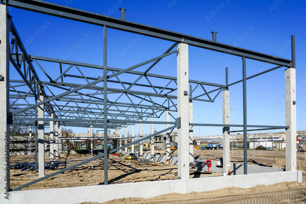 The steel frame of the new building with reinforced concrete supports is under construction The steel frame of the new building with reinforced concrete supports is under construction