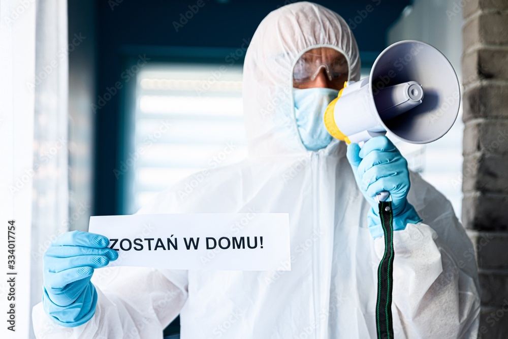 Fototapeta premium Medic holding card with message Stay at home in Polish language