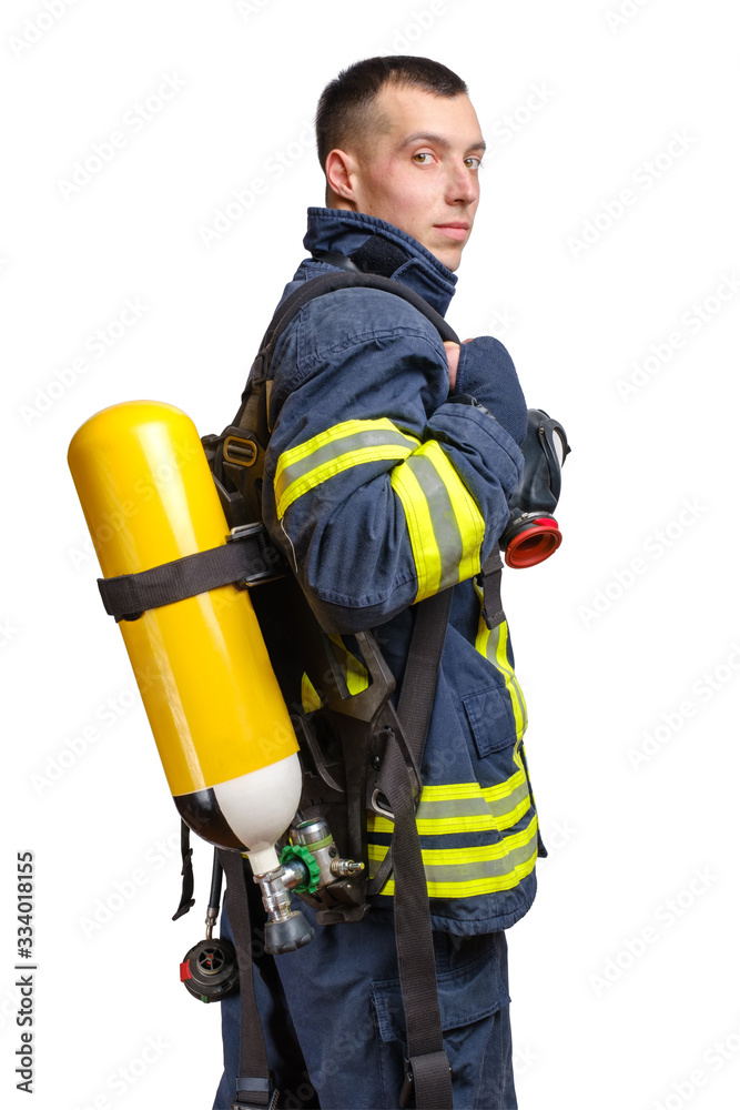 Young caucasian firefighter posing in profile with Full Facepiece Respirator and Breathing Air Cylinder Assembly Young caucasian firefighter posing in profile with Full Facepiece Respirator and Breathing Air Cylinder Assembly