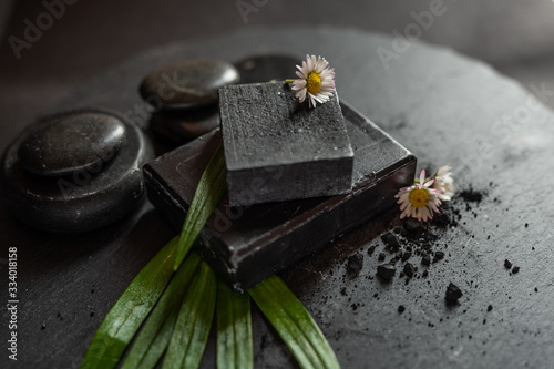 black carbon charcoal soap on a black stone background 