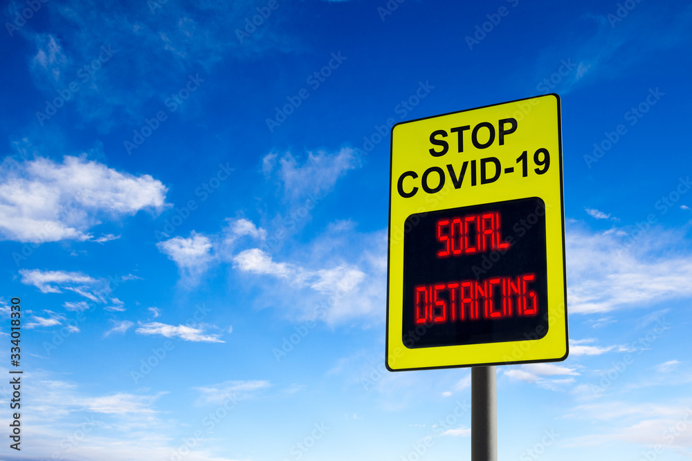 Stop COVID-19 Social Distancing Sign Against Blue Sky With Copy Space Stop COVID-19 Social Distancing Sign Against Blue Sky With Copy Space