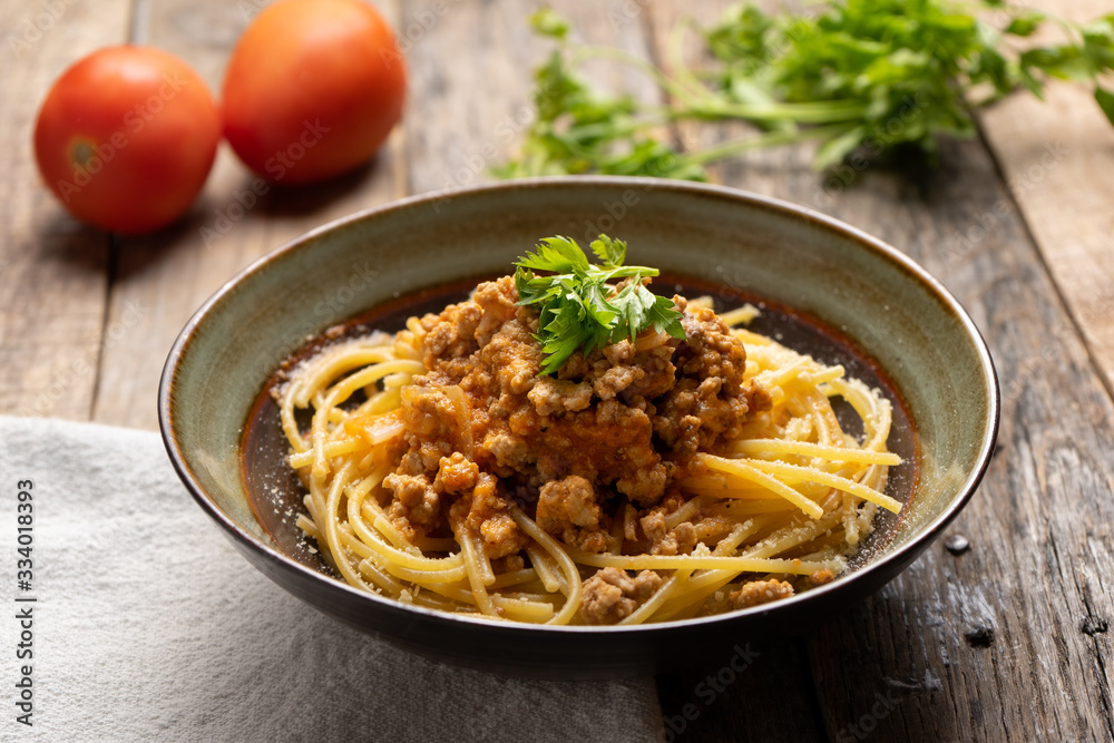Spaghetti bolognese with parmesan cheese on wooden background Spaghetti bolognese with parmesan cheese on wooden background